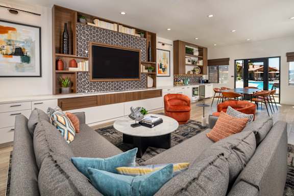 A modern living room with a grey sofa and a flat screen TV mounted on the wall.