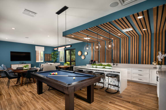 a living room with a pool table and a kitchen