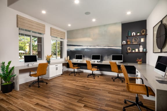 a modern office with desks and chairs and a painting on the wall