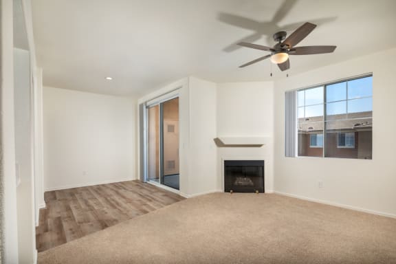 a living room with a fireplace and a ceiling fan