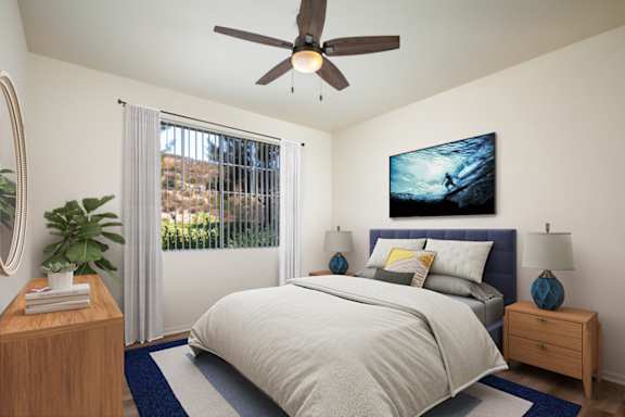 A bedroom with a bed, nightstand, and a ceiling fan.
