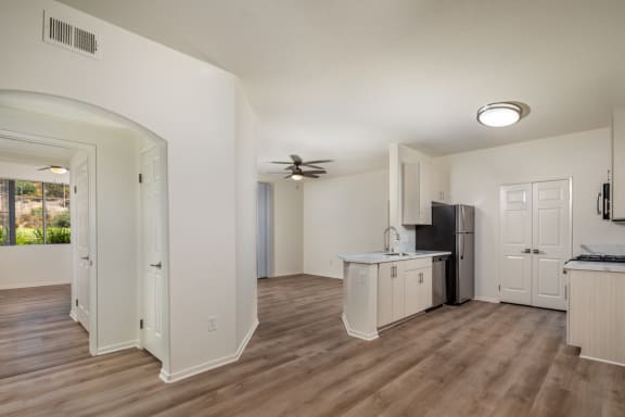 an open kitchen and living room with a ceiling fan