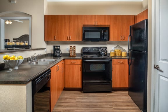 our apartments have a modern kitchen with black appliances and wood cabinets