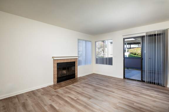 A room with a fireplace and sliding glass doors.