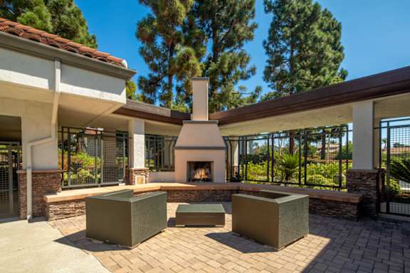 A patio with a fireplace and seating area.