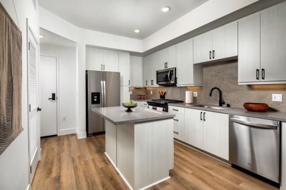 Kitchen with white cabinets and stainless steel appliances at VORA LUX, Mission Valley, California, 92120