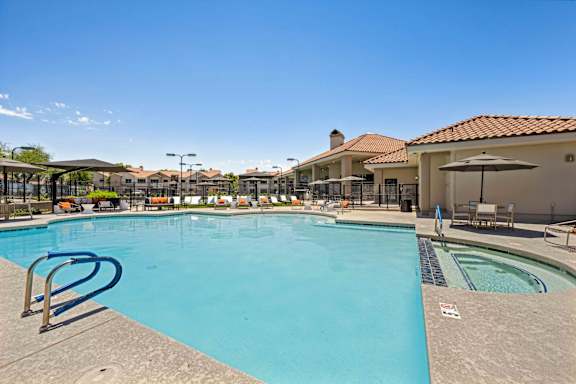 A large outdoor swimming pool with a slide and sun loungers.