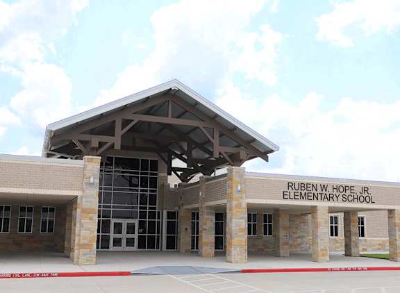 The front of Ruben W. Hope Jr. Elementary School is shown with a clear blue sky in the background.