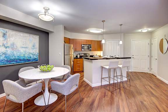 A kitchen with a dining table and chairs.