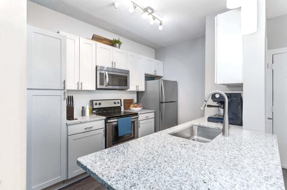 an open kitchen with granite counter tops and stainless steel appliances