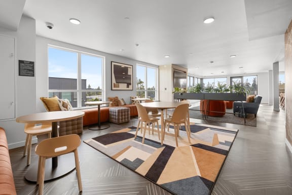 a seating area with tables and chairs at the enclave at woodbridge apartments in sugar land at Ion Town Center, Shoreline, WA