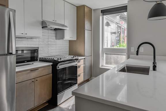 A modern kitchen with stainless steel appliances and a marble countertop.