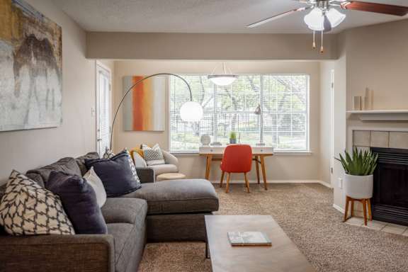 A living room with a grey couch and a red chair.