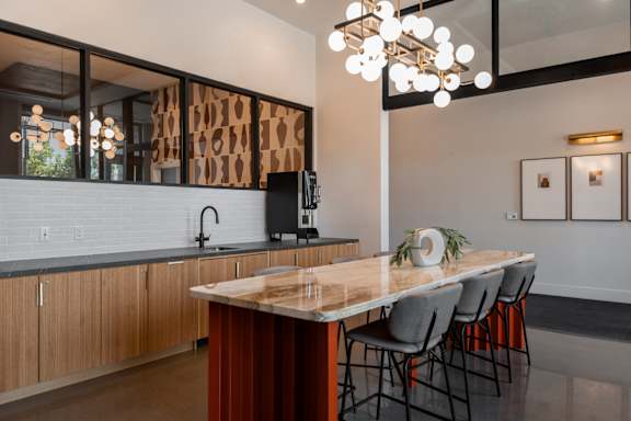 A kitchen with a wooden island and chairs.