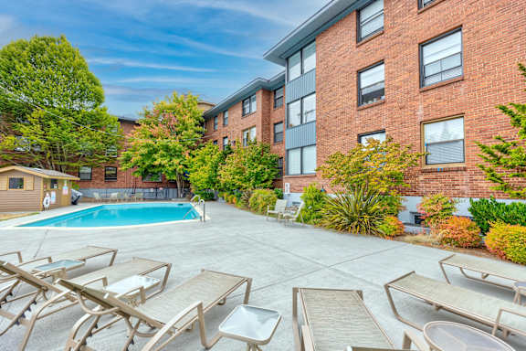 A pool surrounded by sun loungers and trees at Lock Vista, 98107