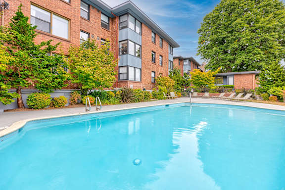 A swimming pool in front of a red brick building at Lock Vista, Seattle, 98107
