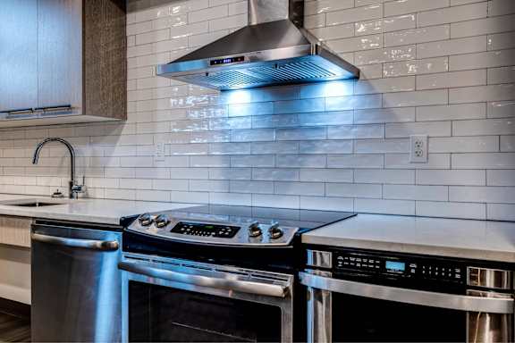 A modern kitchen with a stainless steel oven and a range hood above it. at Lock Vista, Seattle, 98107