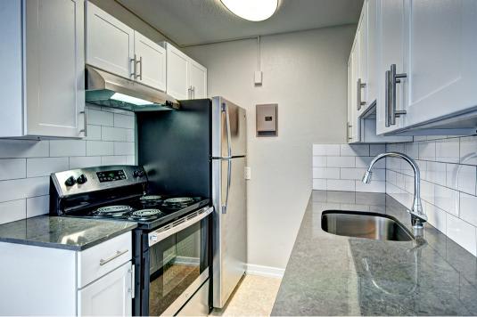 A kitchen with a black refrigerator, stove, and oven.at Lock Vista, Seattle, WA, 98107