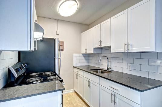 A kitchen with white cabinets and a black stove top at Lock Vista, Seattle, 98107