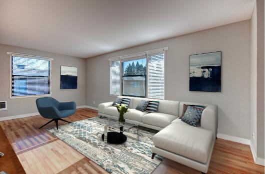 A living room with a grey couch, a blue chair, and a rug at Lock Vista, Seattle, WA