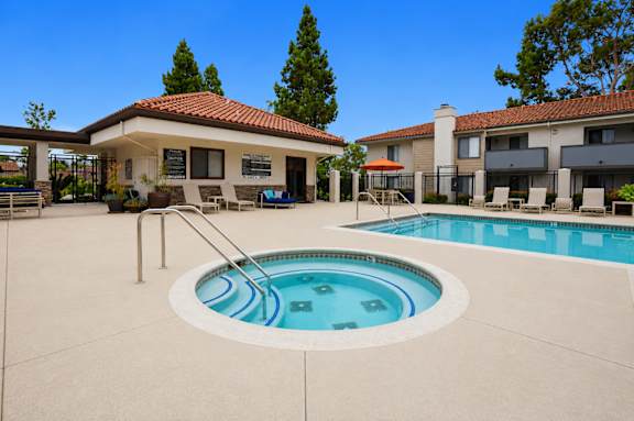 A swimming pool in a backyard with a house in the background.