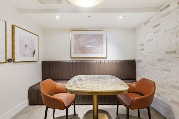 A dining room with a round table and four chairs.
