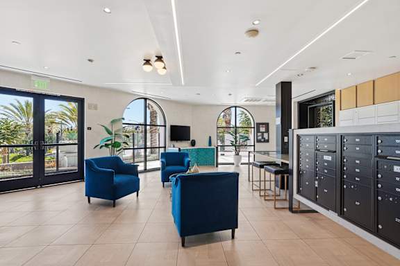 A spacious room with blue chairs and a television.
