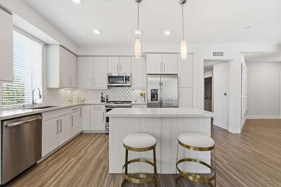 A kitchen with a bar stool in front of the island.