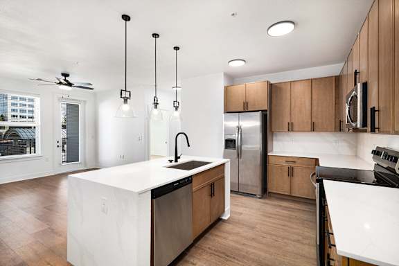 A modern kitchen with wooden cabinets and a white island.