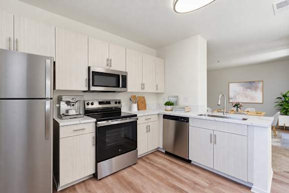 A modern kitchen with stainless steel appliances and white cabinets.