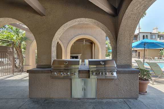 A barbecue grill is built into a wall with arches.