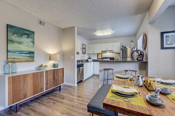 A modern kitchen with a dining table set for a meal.