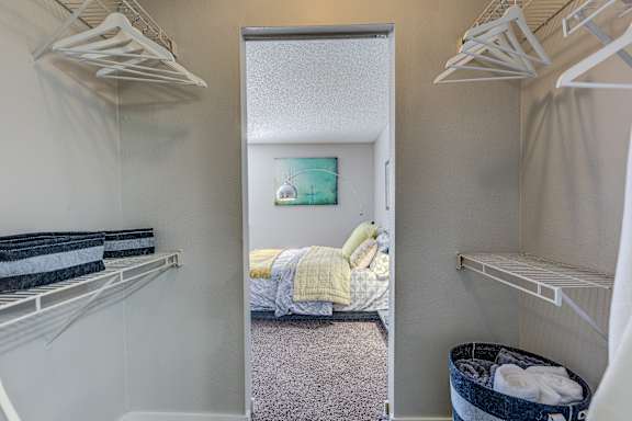 A small bedroom with a bed, a dresser, and a closet.