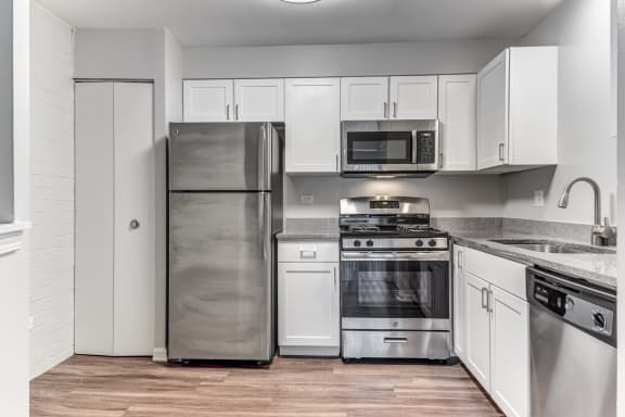 a kitchen with stainless steel appliances and white cabinets