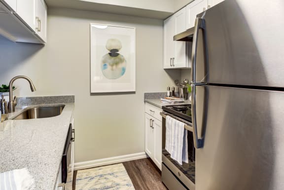 an updated kitchen with stainless steel appliances and granite counter tops