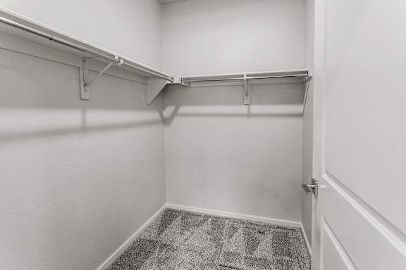 A white hallway with a carpeted floor and metal railings.
