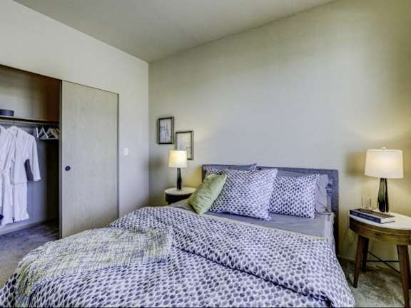 A bed with a blue and white patterned comforter is in the image.