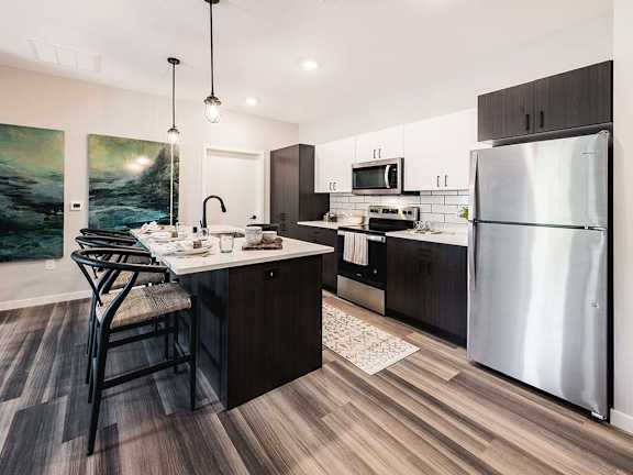 A modern kitchen with a large island and stainless steel appliances.