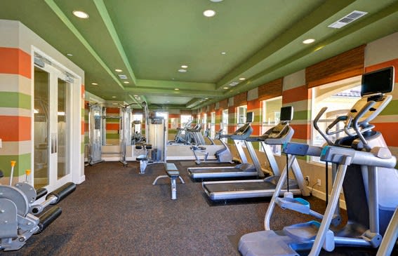 A gym with treadmills, weights, and exercise machines at RiverEdge Terrace* Apartments, California, 92154
