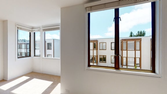 a bedroom with a large window and a view of a building