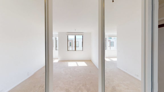 a bedroom with white walls and a window