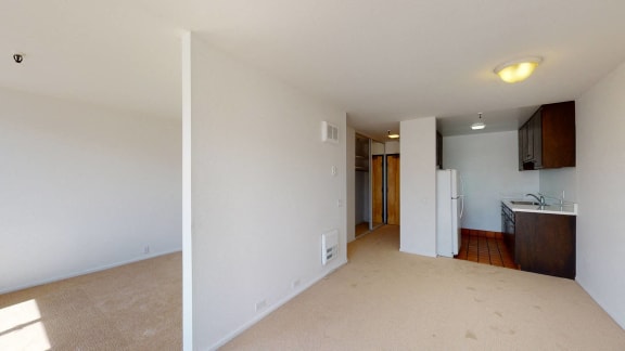 a bedroom with a medium sized bed and a kitchen with a refrigerator and sink