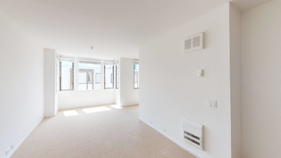 a bedroom with a large window and white walls