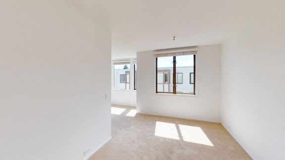 a bedroom with white walls and a large window