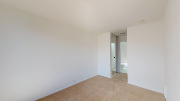 a bedroom with white walls and carpet