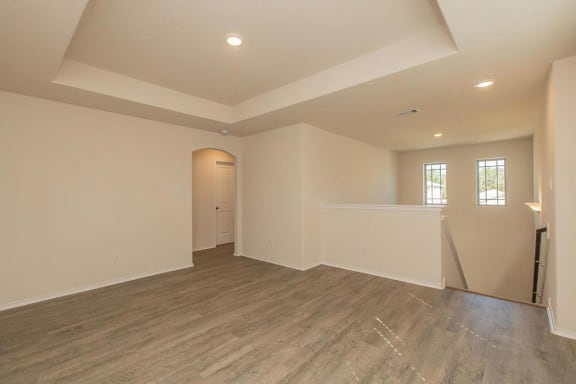 a empty living room with a wood floor and white walls