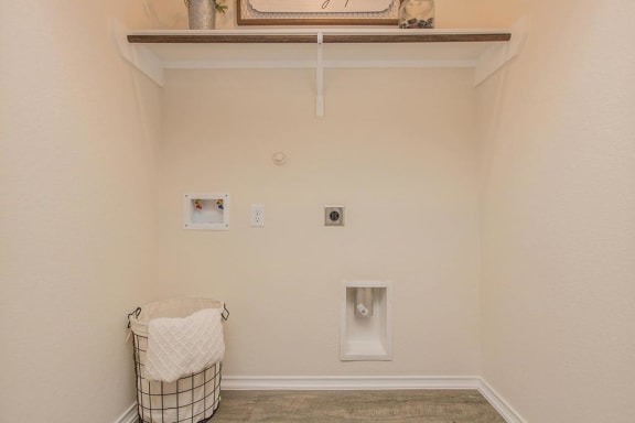 a laundry room with a basket and a urinal on the wall