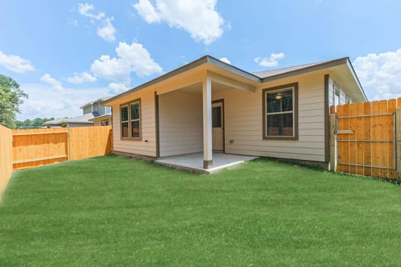 a home with a lawn and a wooden fence
