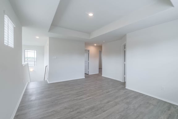 a living room with white walls and wood floors