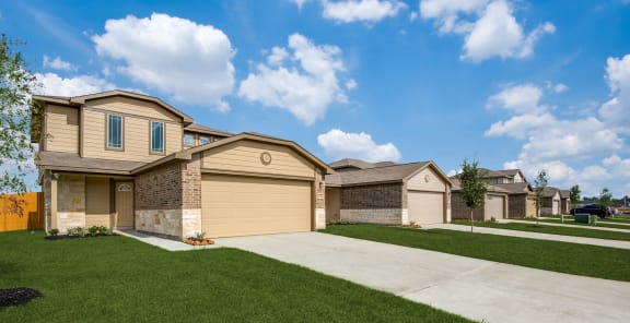 a beige house with a sidewalk in front of it